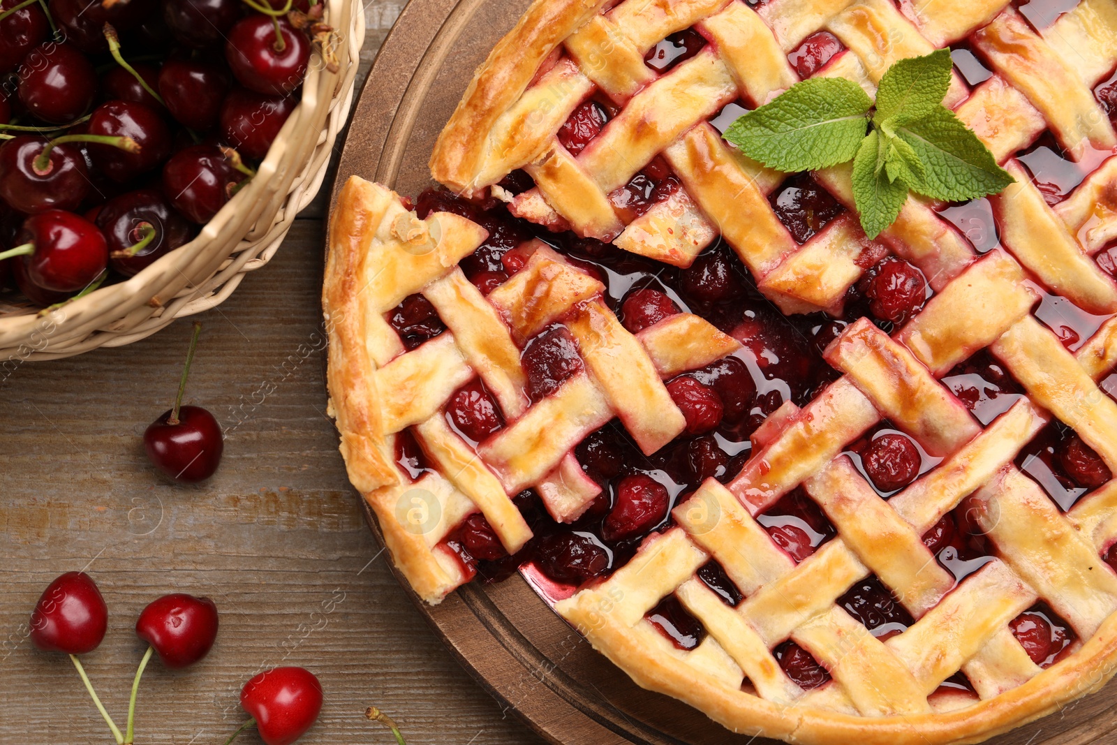 Tasty cut cherry pie and berries on wooden table, flat lay Photo of Tasty cut cherry pie and berries on wooden table, flat lay