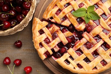 Photo of Tasty cut cherry pie and berries on wooden table, flat lay