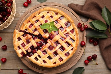 Photo of Tasty cut cherry pie and berries on wooden table, flat lay