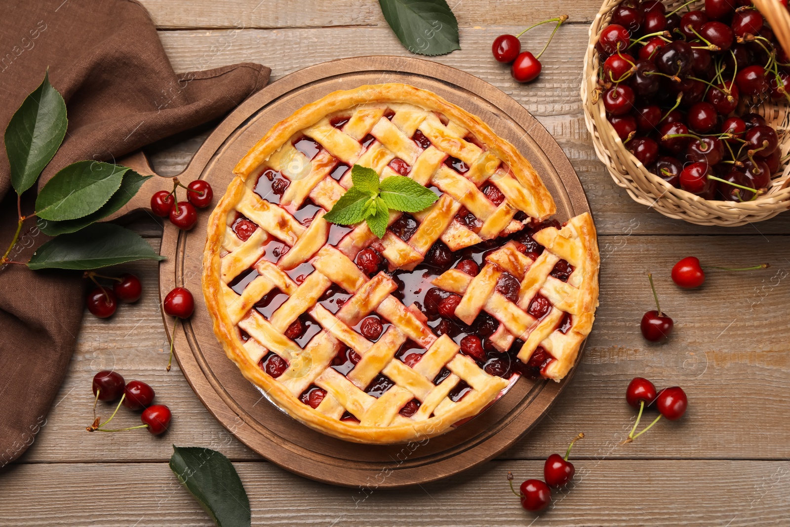 Tasty cut cherry pie and berries on wooden table, flat lay Photo of Tasty cut cherry pie and berries on wooden table, flat lay