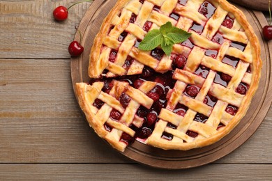 Photo of Tasty cut cherry pie and berries on wooden table, top view
