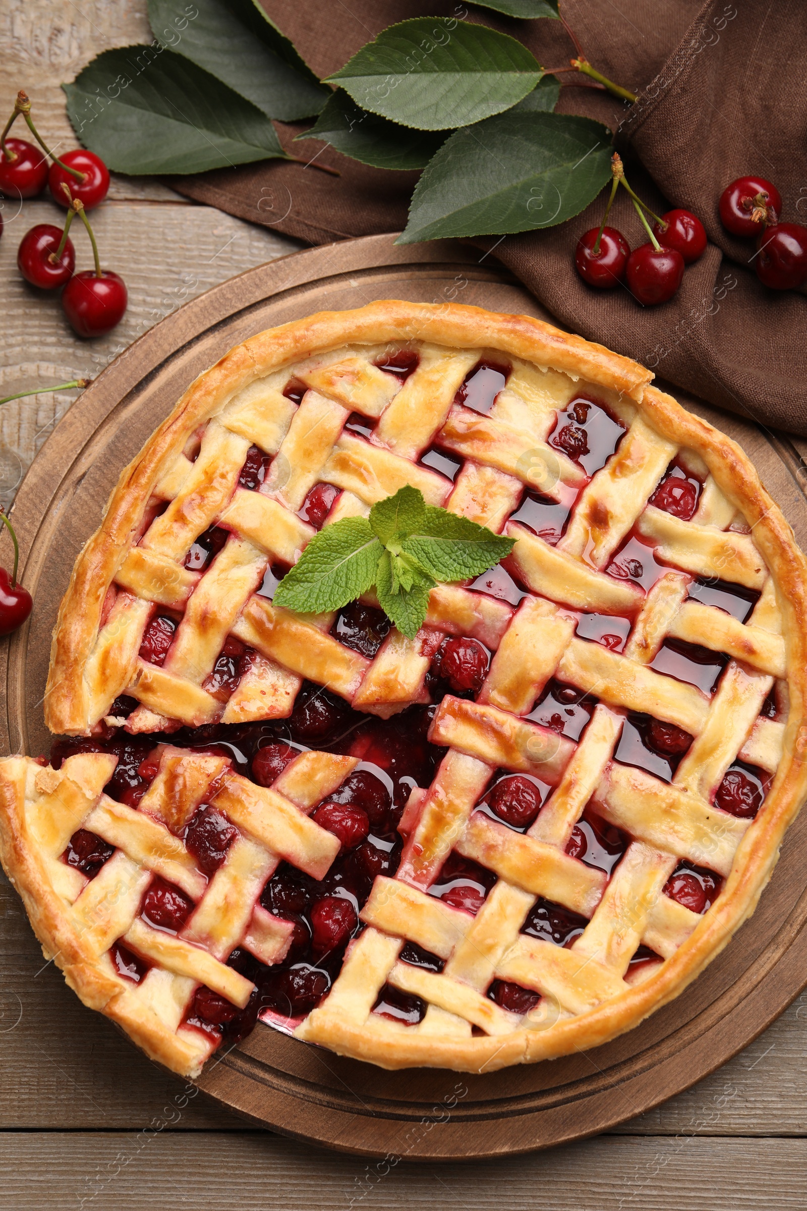Photo of Tasty cut cherry pie and berries on wooden table, flat lay
