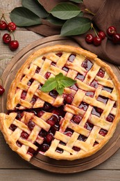 Photo of Tasty cut cherry pie and berries on wooden table, flat lay
