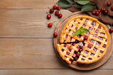 Photo of Tasty cut cherry pie and berries on wooden table, flat lay. Space for text