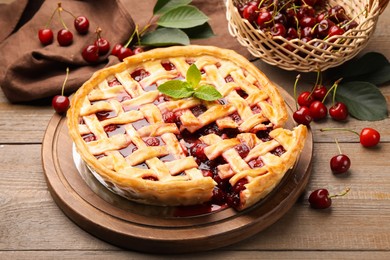 Photo of Tasty cut cherry pie and berries on wooden table, closeup