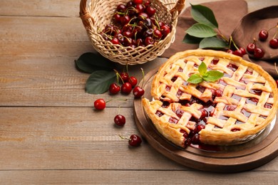 Photo of Tasty cut cherry pie and berries on wooden table, closeup. Space for text