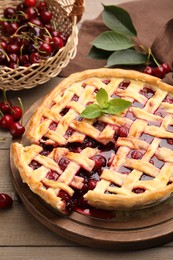 Photo of Tasty cut cherry pie and berries on wooden table, closeup