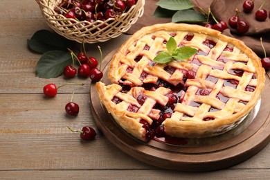 Photo of Tasty cut cherry pie and berries on wooden table, closeup
