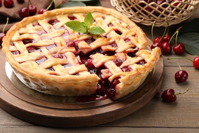 Photo of Tasty cut cherry pie and berries on wooden table, closeup
