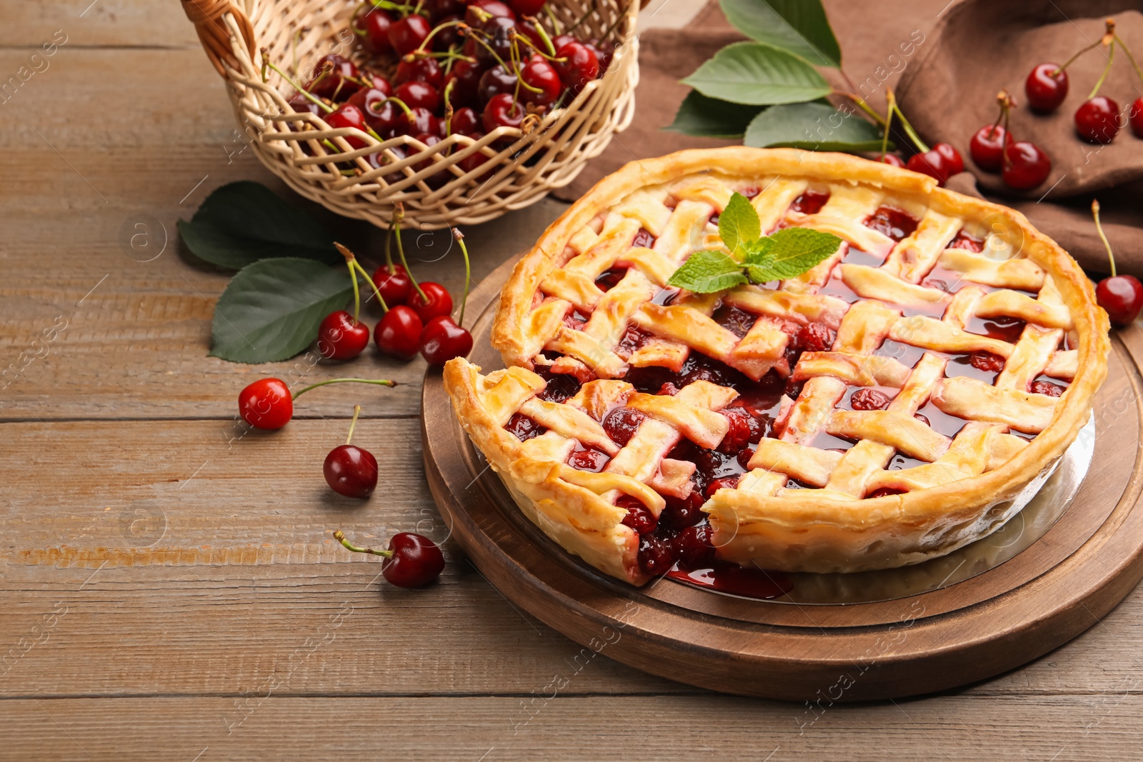 Photo of Tasty cut cherry pie and berries on wooden table, closeup