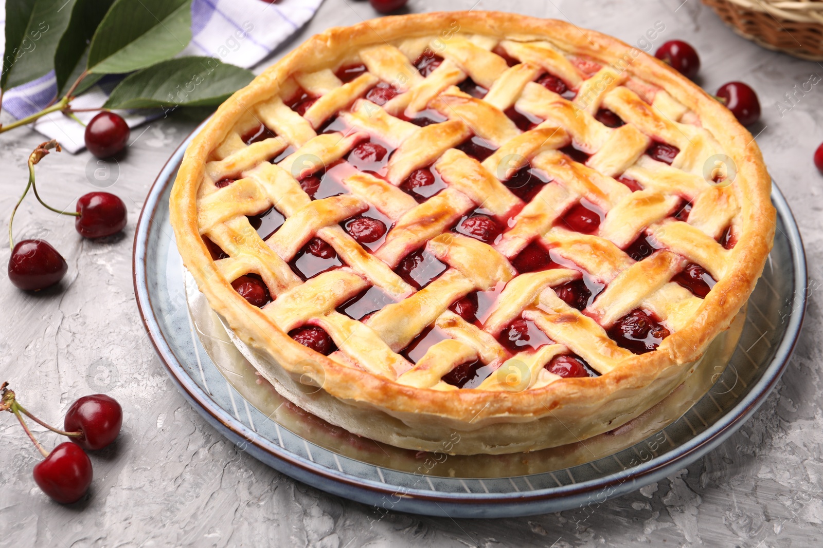 Tasty cherry pie and berries on grey textured table, closeup Photo of Tasty cherry pie and berries on grey textured table, closeup