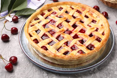 Photo of Tasty cherry pie and berries on grey textured table, closeup
