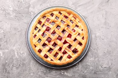 Photo of Tasty cherry pie on grey textured table, top view