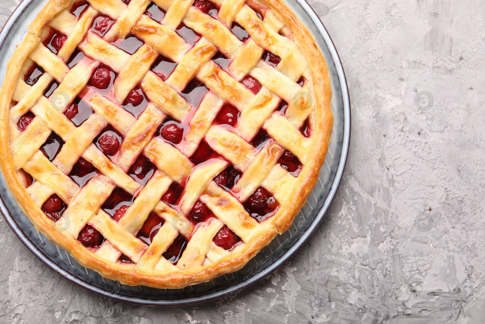 Tasty cherry pie on grey textured table, top view Photo of Tasty cherry pie on grey textured table, top view
