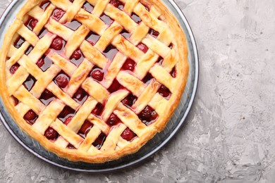 Photo of Tasty cherry pie on grey textured table, top view