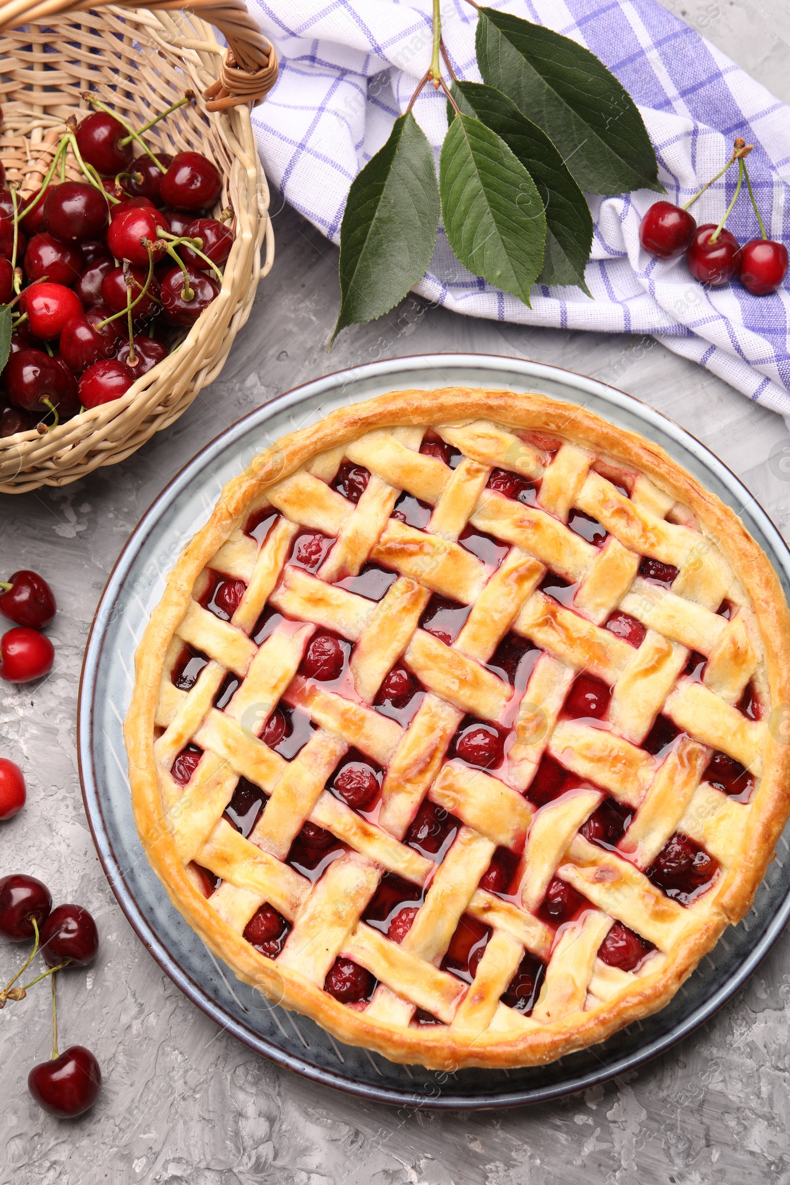 Tasty cherry pie and berries on grey textured table, flat lay Photo of Tasty cherry pie and berries on grey textured table, flat lay