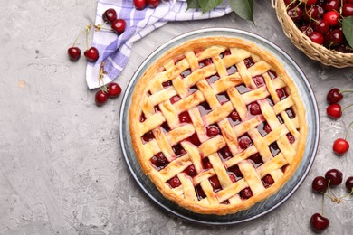 Photo of Tasty cherry pie and berries on grey textured table, flat lay