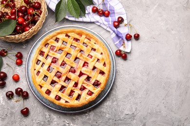 Photo of Tasty cherry pie and berries on grey textured table, flat lay