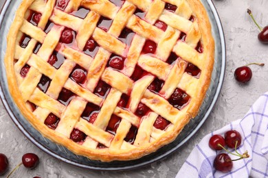 Photo of Tasty cherry pie and berries on grey textured table, flat lay