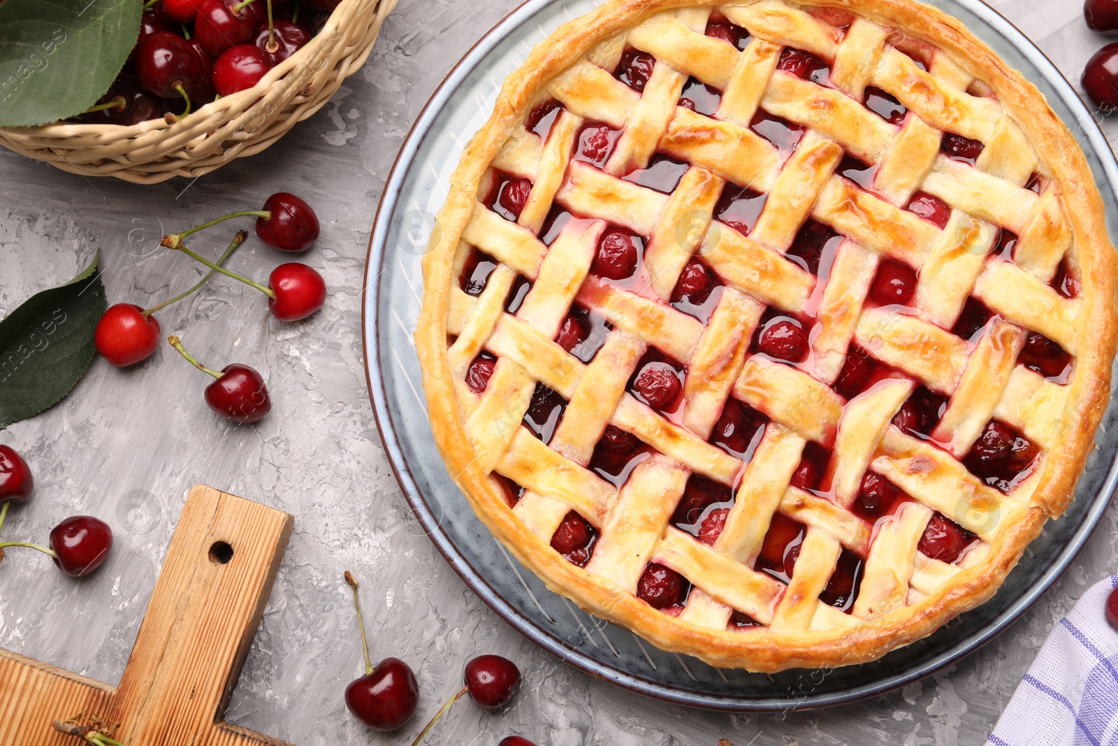 Tasty cherry pie and berries on grey textured table, flat lay Photo of Tasty cherry pie and berries on grey textured table, flat lay
