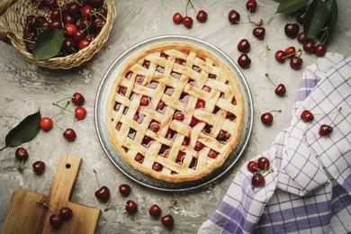 Photo of Tasty cherry pie and berries on grey textured table, flat lay
