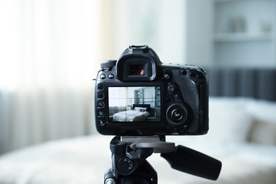 Photo of Shooting large bed with professional photo camera in studio, selective focus