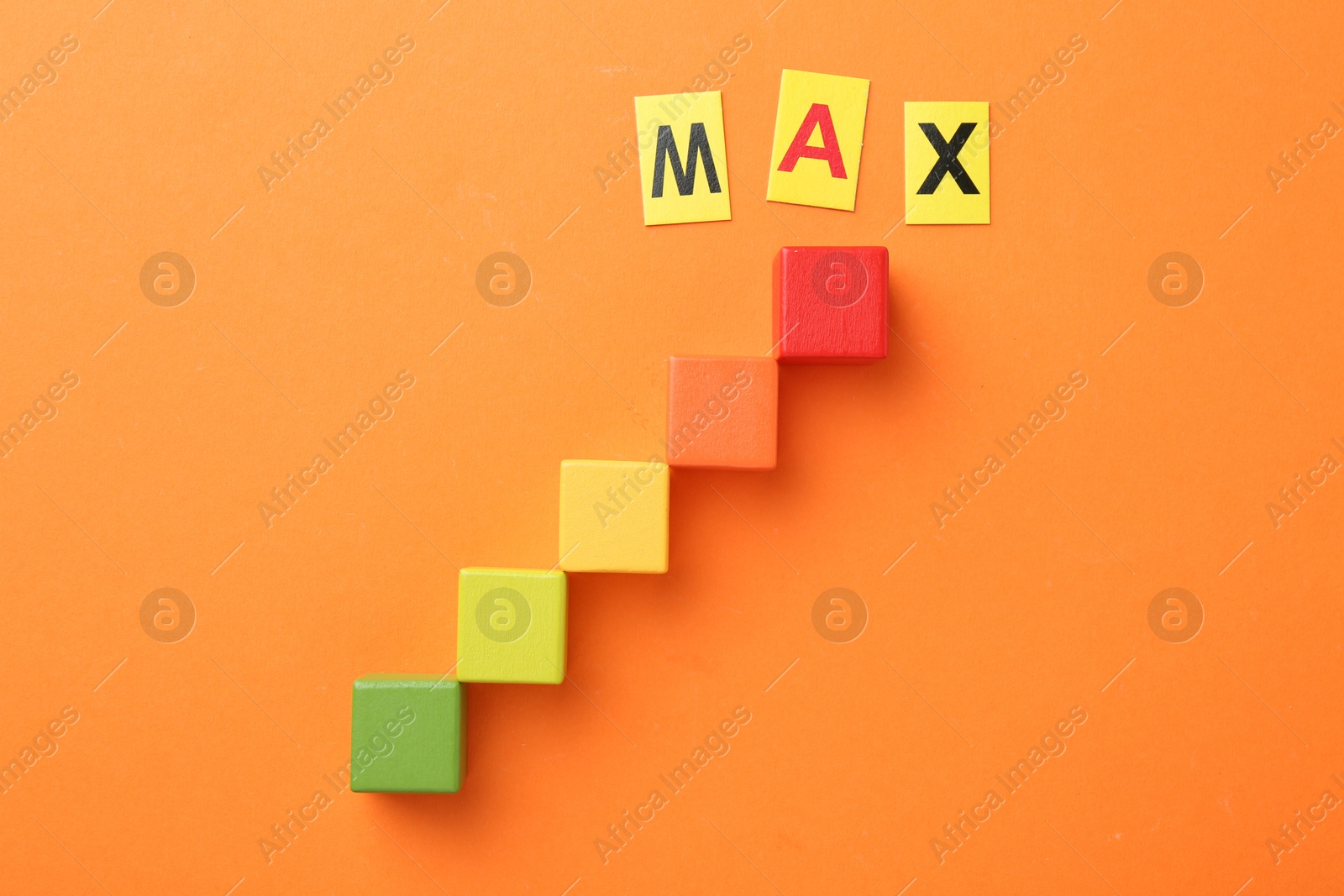 Colorful cubes and word Max on orange background, flat lay Photo of Colorful cubes and word Max on orange background, flat lay
