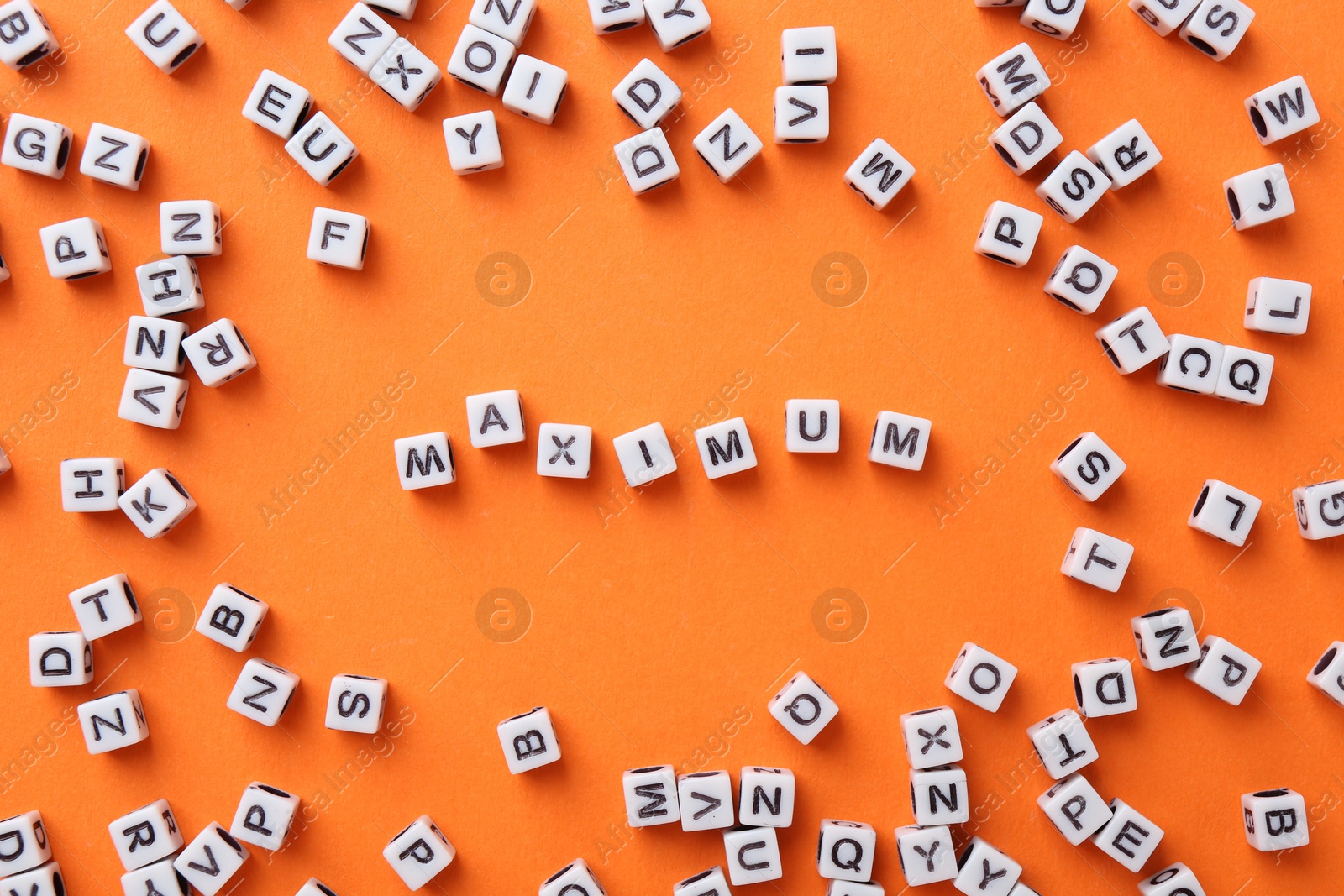 Word Maximum made of cubes on orange background, flat lay Photo of Word Maximum made of cubes on orange background, flat lay