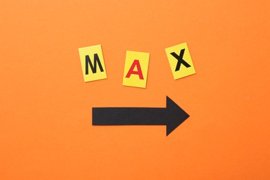 Photo of Word Maximum and arrow on orange background, top view