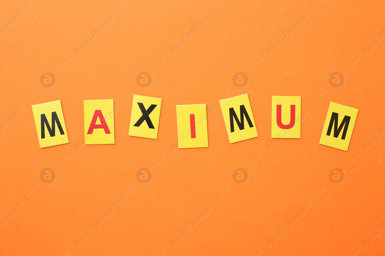 Word Maximum on orange background, top view Photo of Word Maximum on orange background, top view