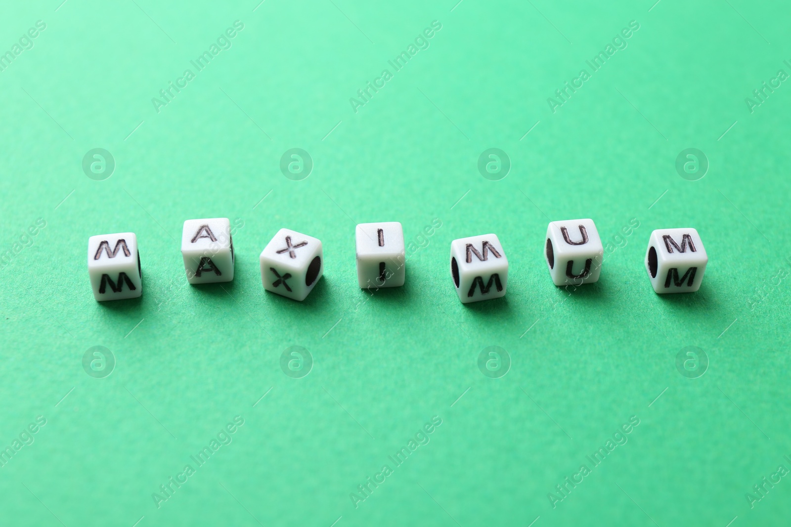 Word Maximum made of cubes on green background Photo of Word Maximum made of cubes on green background