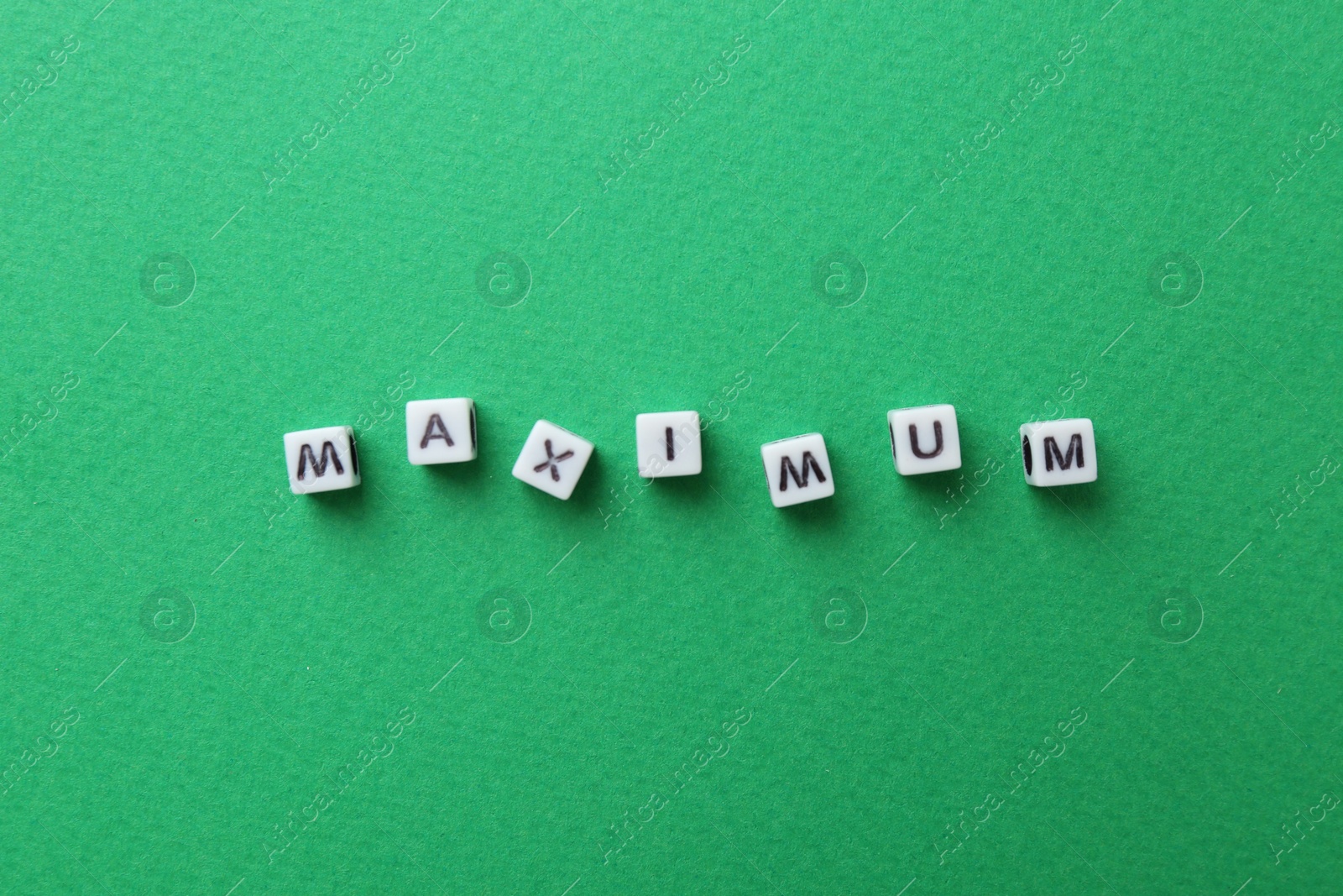 Word Maximum made of cubes on green background, top view Photo of Word Maximum made of cubes on green background, top view