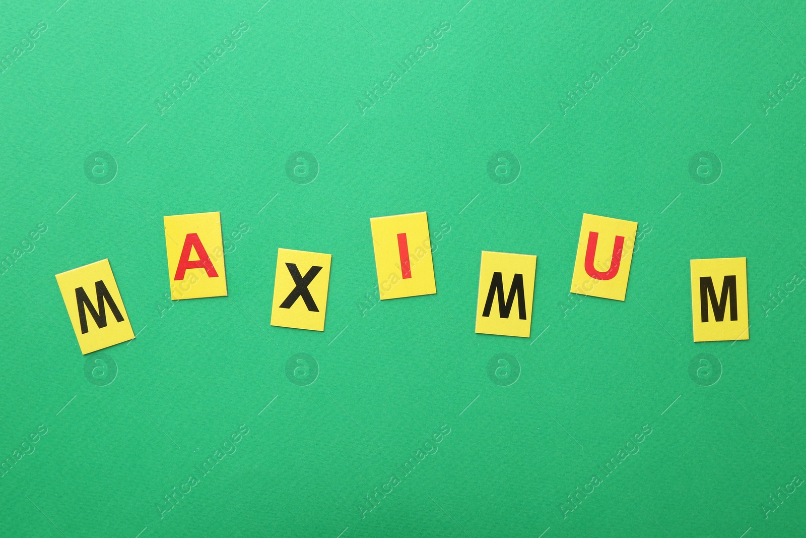 Word Maximum on green background, top view Photo of Word Maximum on green background, top view