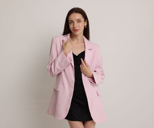 Photo of Portrait of beautiful woman in stylish outfit on white background