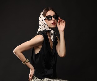 Photo of Beautiful woman in stylish outfit on black background
