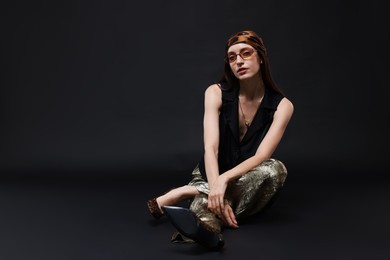 Photo of Full-length portrait of beautiful woman in stylish outfit on black background, space for text