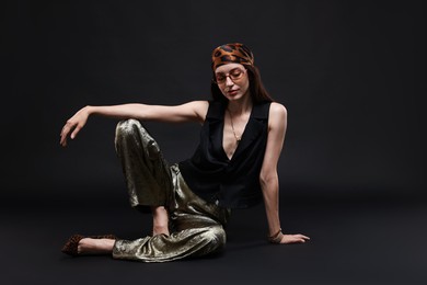 Photo of Full-length portrait of beautiful woman in stylish outfit on black background