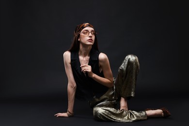 Photo of Full-length portrait of beautiful woman in stylish outfit on black background