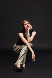 Photo of Full-length portrait of beautiful woman in stylish outfit on black background