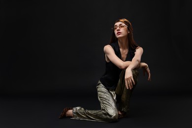 Photo of Full-length portrait of beautiful woman in stylish outfit on black background, space for text