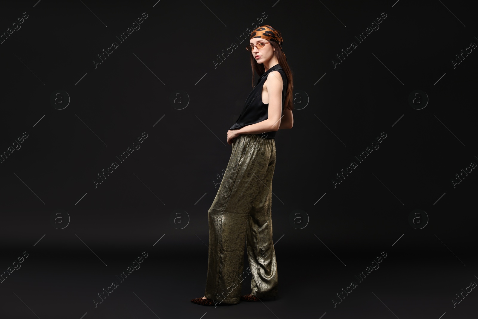 Full-length portrait of beautiful woman in stylish outfit on black background Photo of Full-length portrait of beautiful woman in stylish outfit on black background
