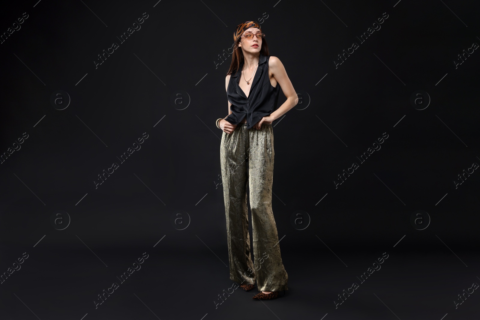 Full-length portrait of beautiful woman in stylish outfit on black background Photo of Full-length portrait of beautiful woman in stylish outfit on black background