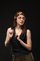 Photo of Portrait of beautiful woman in stylish outfit on black background