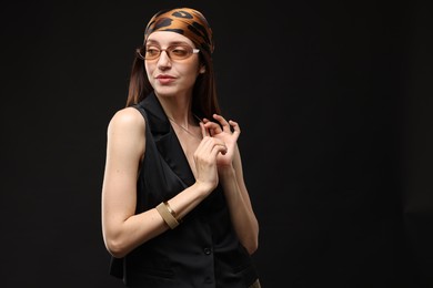 Photo of Portrait of beautiful woman in stylish outfit on black background, space for text