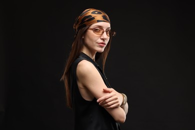 Photo of Portrait of beautiful woman in stylish outfit on black background