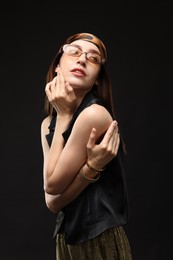 Photo of Portrait of beautiful woman in stylish outfit on black background