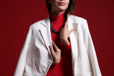 Photo of Beautiful woman in stylish outfit on red background, closeup