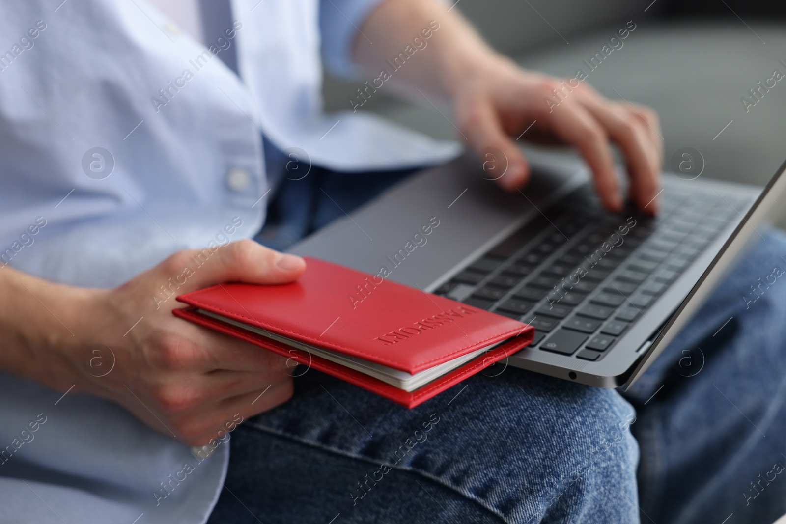 Man with passport using laptop indoors, closeup Photo of Man with passport using laptop indoors, closeup