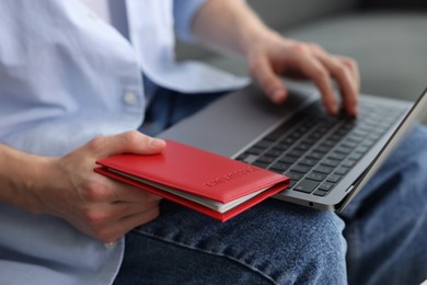 Photo of Man with passport using laptop indoors, closeup