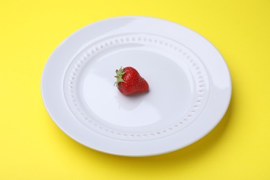 Photo of Plate with fresh strawberry on yellow background, closeup